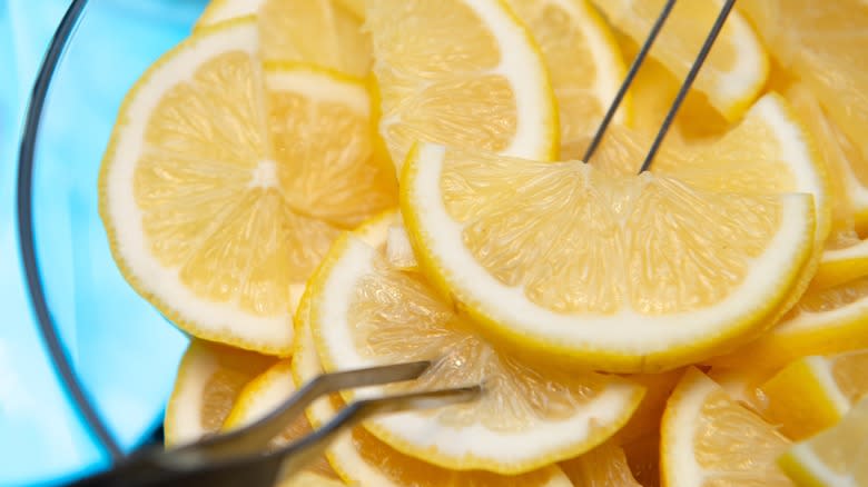 thinly sliced whole lemon pieces pierced with tongs