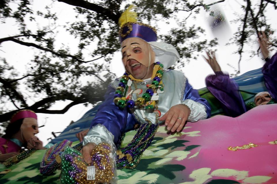 A parade participant throws Mardi Gras beads from a float during Pegasus Parade on St. Charles Ave. in New Orleans' Garden District, Saturday, Feb 18, 2006.