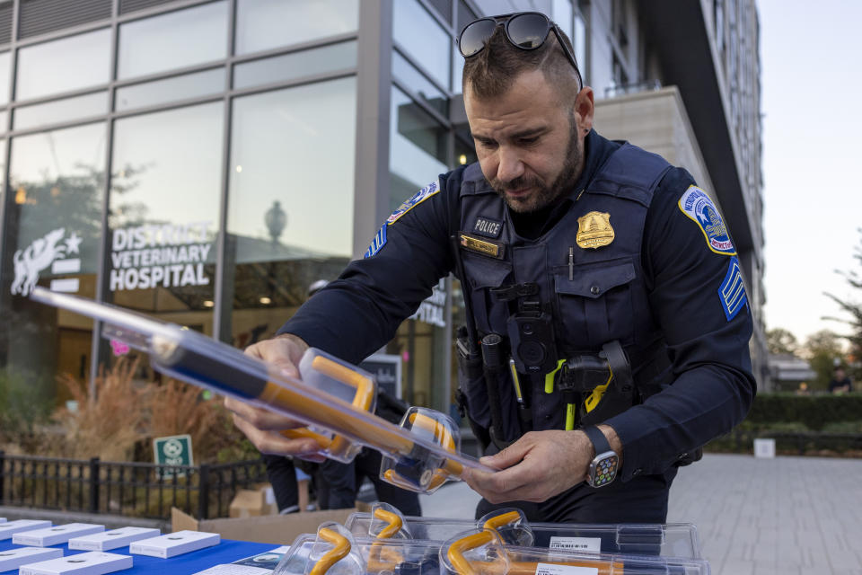 FILE - Metropolitan Police Department Sgt. Anthony Walsh sets out steering wheel locks at an anti-crime event in Washington on Nov. 7, 2023. A physical lock that attaches to the steering wheel can act as a visible deterrent to car thieves. (AP Photo/Amanda Andrade-Rhoades, File)