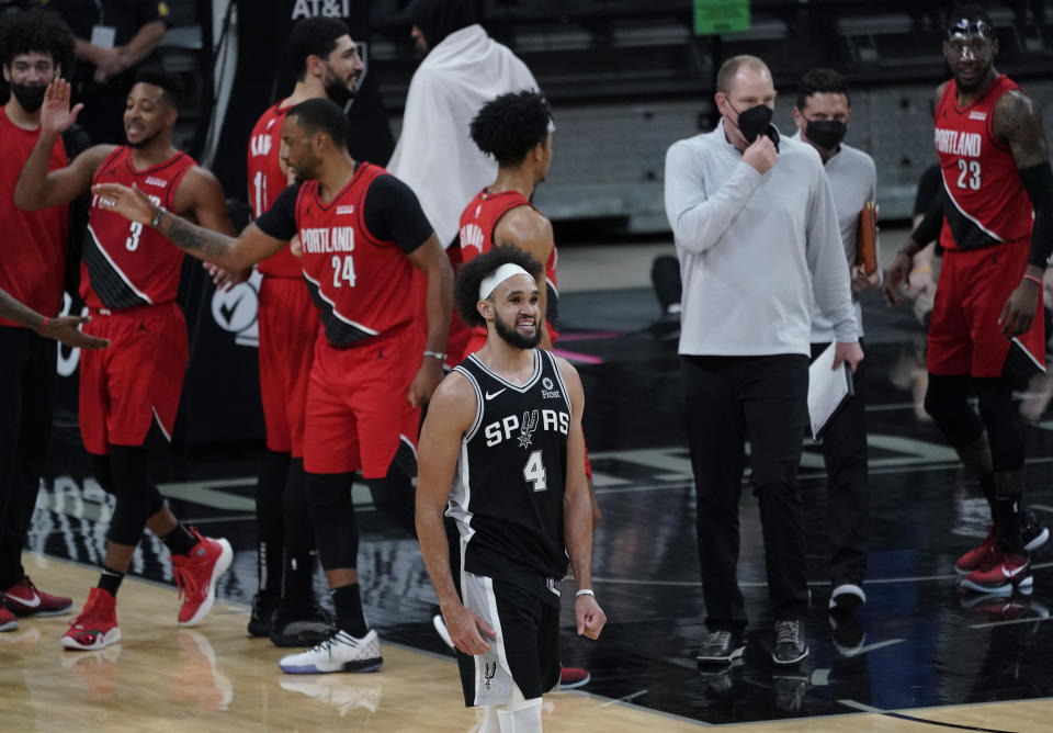 San Antonio Spurs guard Derrick White (4) walks off the court as the Portland Trail Blazers celebrate their win in an NBA basketball game in San Antonio, Friday, April 16, 2021. (AP Photo/Eric Gay)