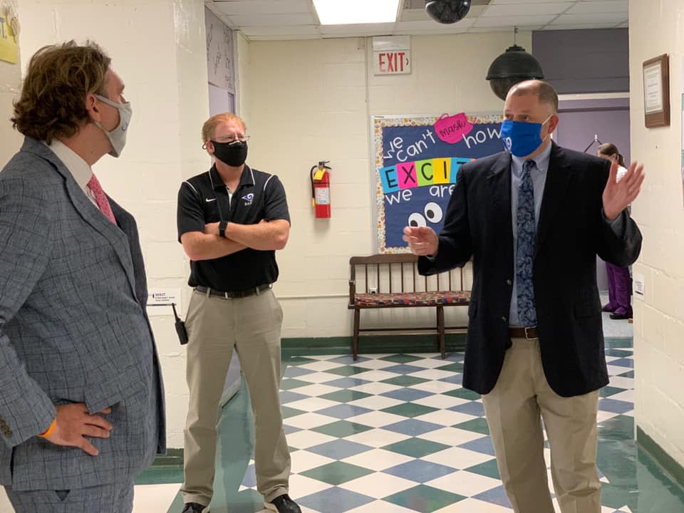 Patrick Miller, superintendent of Greene County Schools, right, speaks with Freebird McKinney, director of legislative and community affairs for the North Carolina State Board of Education, left, with Emery Smith, principal of Snow Hill Primary School.