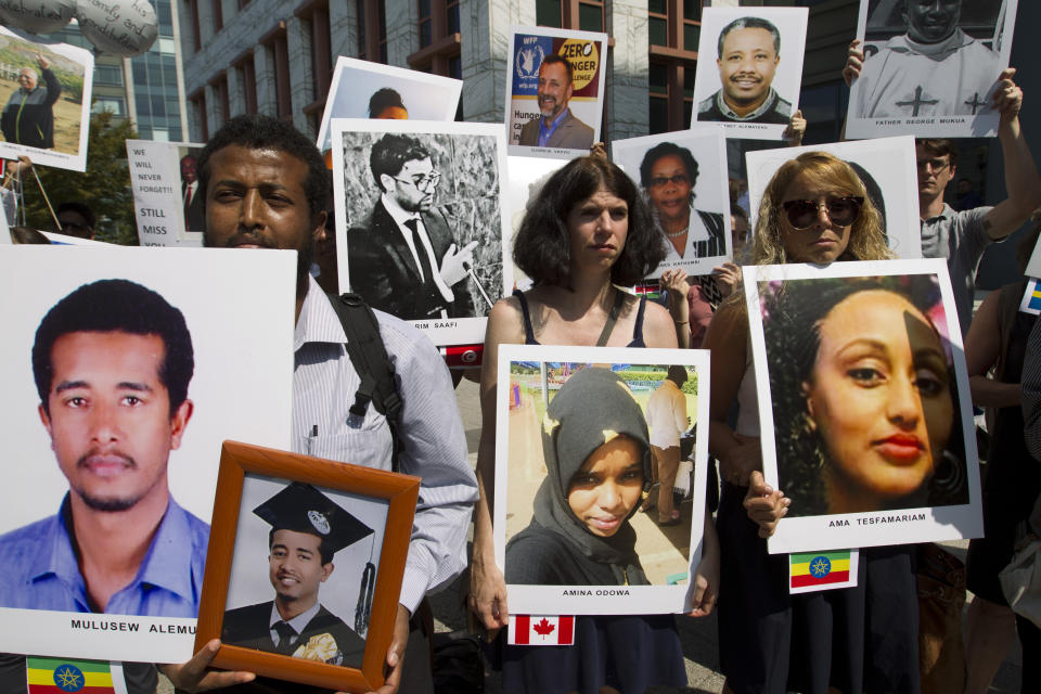 Beza Alemu, left, from Ethiopia, along with other demonstrators, holds pictures of his brother Mulusew Alemu, who died in the plane crash, during a vigil on the six-month anniversary of the crash of a Boeing 737 Max 8, killing 157 people, in Ethiopia on March 10, which has resulted in the grounding hundreds of the planes worldwide, outside of the Department of Transportation, Tuesday, Sept. 10, 2019 in Washington. (AP Photo/Jose Luis Magana)