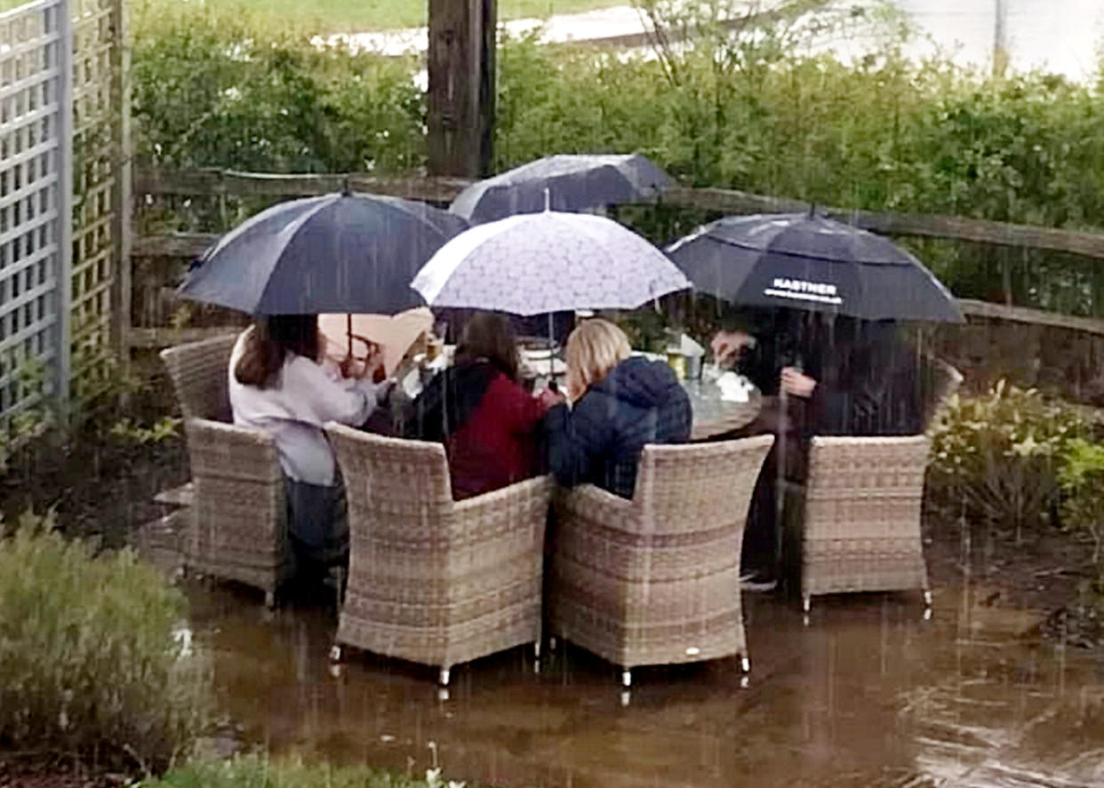 A group of hardy pub goers have raised a smile after being pictured enjoying an outdoor pint - in the pouring rain.  See SWNS story SWPLpub.  The comical photo shows eager drinkers huddled under umbrellas in a beer garden and not letting the wet weather get in the way of their Bank Holiday weekend celebrations.  It was taken yesterday (May 1) outside The Cranberry Farm pub, in Exeter, Devon, and has been hailed as a true sign of British grit.  The pub, owned by Hall and Woodhouse brewery, opened again for outdoor service last Thursday (April 29).