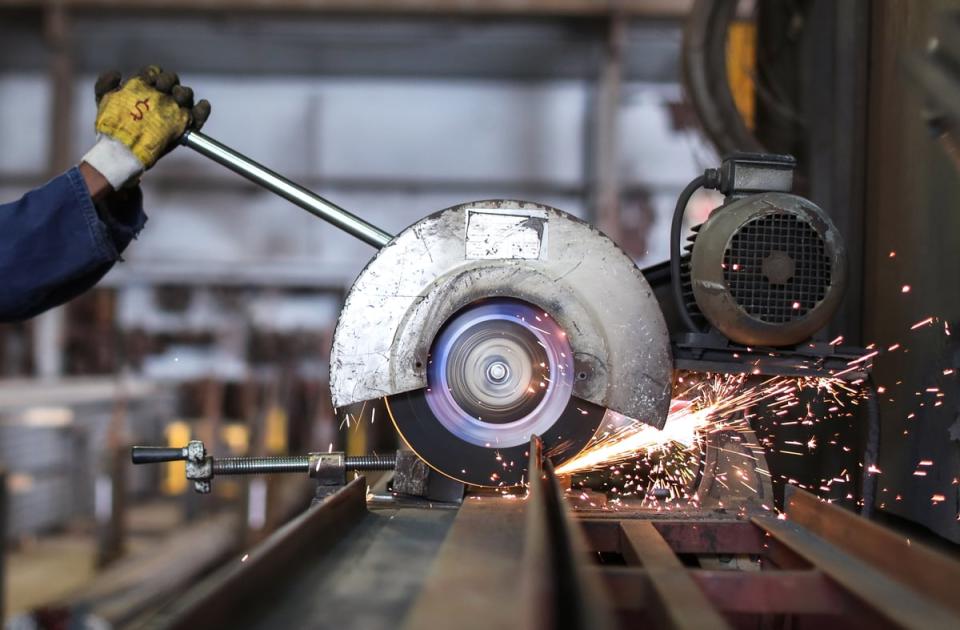 A person operates a circular saw in a factory. 