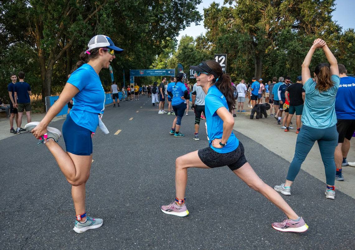 Marisa Crawford of Fair Oaks, right, stretches with Abby Liske of Sacramento before the Great American Triathlon on Saturday, July 20, 2024.