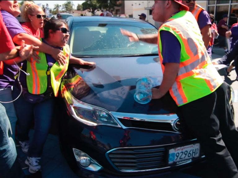 Man drives car into crowd protesting Trump immigration policy