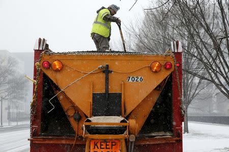 A worker stands on top of a salt truck in Washington January 22, 2016. REUTERS/Jonathan Ernst