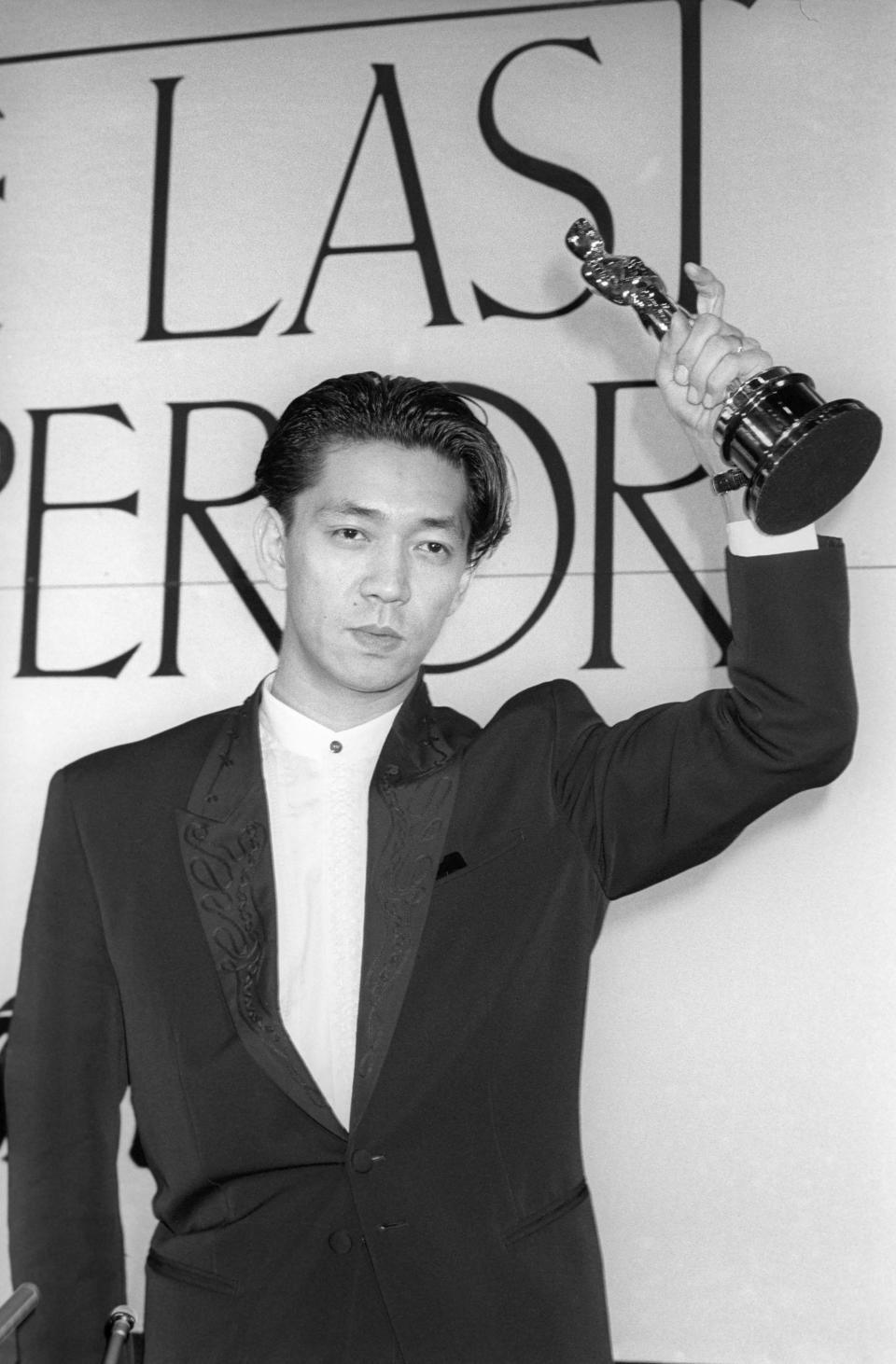ARCHIVO - Ryuichi Sakamoto sostiene su Premio de la Academia por la música de la película "The Last Emperor" en Tokio, en abril de 1988. La empresa discográfica japonesa Avex dijo que Sakamoto, quien hizo la música de películas como "The Last Emperor" y "The Revenant", ha muerto. Tenía 71 años. Falleció el 28 de marzo de acuerdo con un comunicado enviado el 2 de abril de 2023. (Kyodo News vía AP)