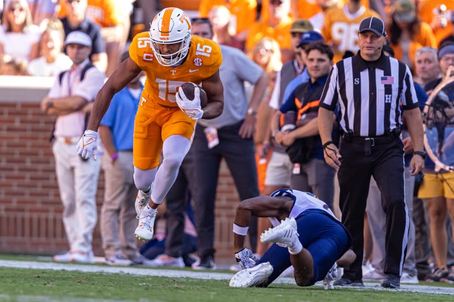 Tennessee wide receiver Bru McCoy (15) leaps to avoid being tackled by UTSA linebacker Donyai Taylor, bottom right, during the first half of an NCAA college football game Saturday, Sept. 23, 2023, in Knoxville, Tenn. (AP Photo/Wade Payne)