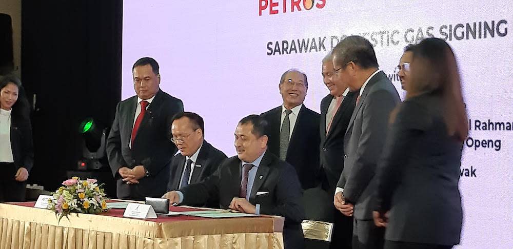 Petros CEO Datuk Sauu Kakok (seated, left) and Petronas senior vice president Mohamed Firouz Asnan sign the domestic gas agreement, as Deputy Chief Minister Datuk Amar Awang Tengah Ali Hasan (standing, third right) looks on, in Kuching February 12, 2020. — Picture by Sulok Tawie