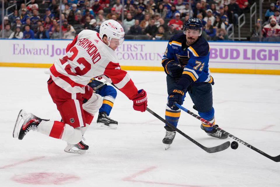 Red Wings forward Lucas Raymond shoots past the Blues' Justin Faulk during the third period of the Wings' 6-4 win on Tuesday, Dec. 12, 2023, in St. Louis.
