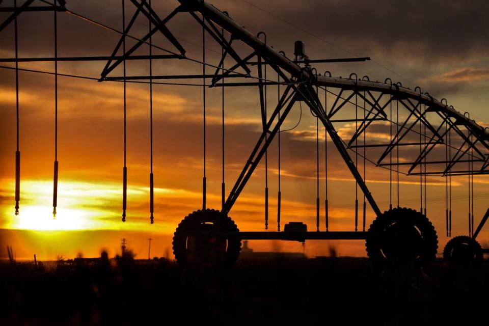 A center pivot irrigation sprinkler is silhouetted against the sky at sunset near Deerfield, Kansas, in January. These sprinkler systems use water more efficiently than the old flood irrigation methods that preceded them, but new technology can help farmers conserve even more.