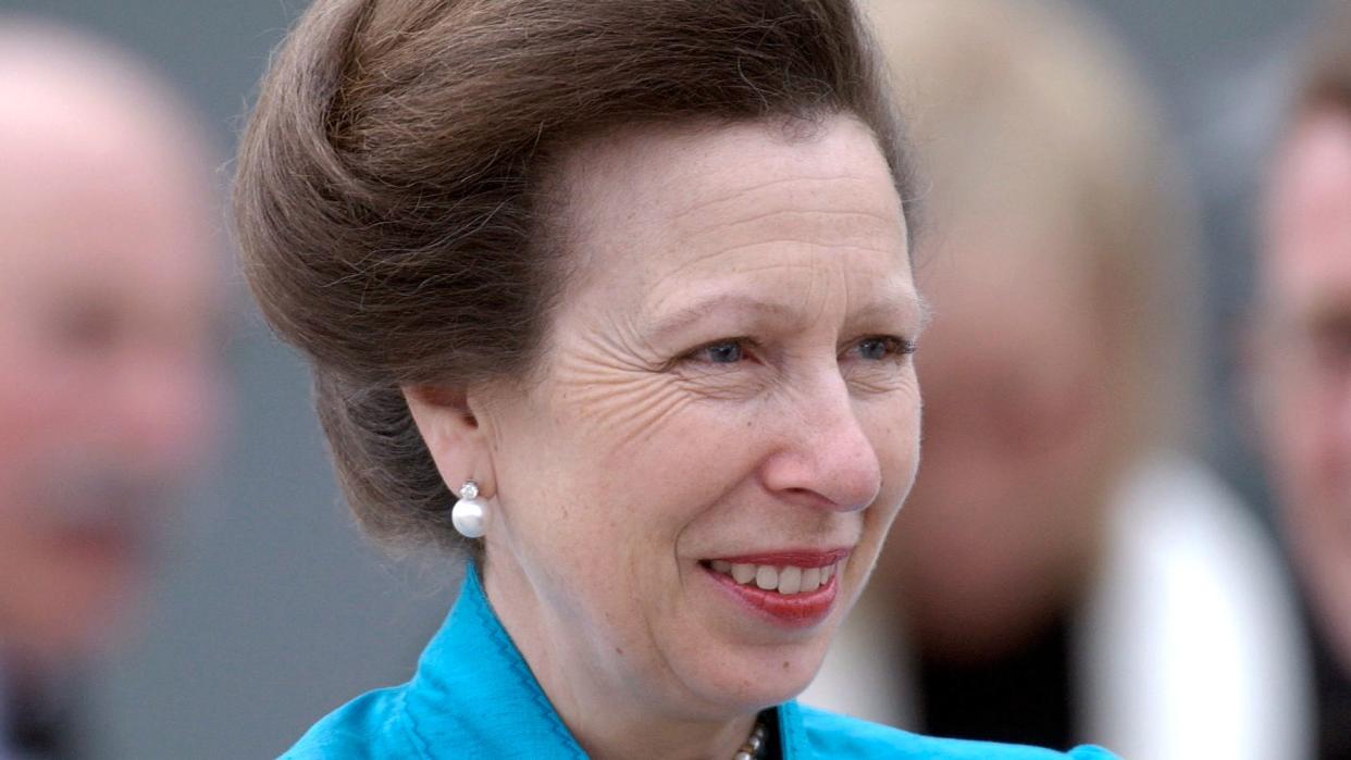 Princess Anne in a blue jacket with her hair up