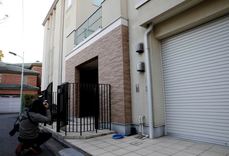 A photographer takes a picture of an exterior of the Tokyo residence of former Nissan chairman Carlos Ghosn, while prosecutors raid the house, in Tokyo