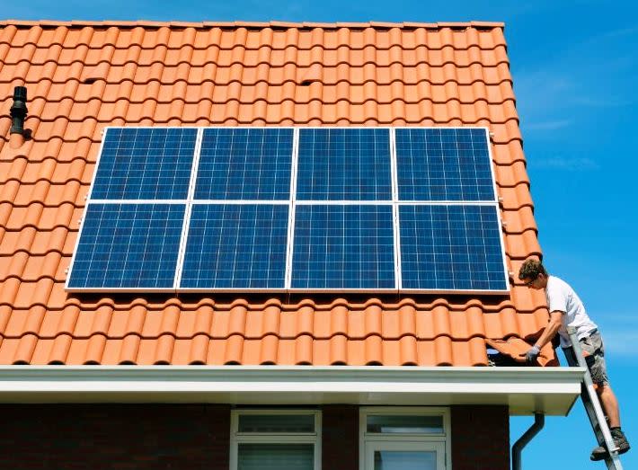 Someone puts solar panels on a rooftop.