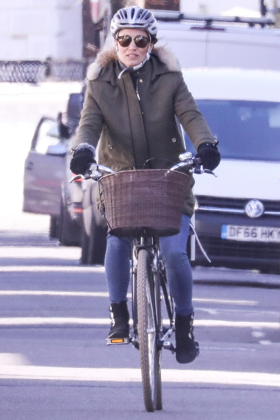 <p>Pippa Matthews rides her bike through West London on Monday wearing a green fur-lined parka and black suede boots.</p>