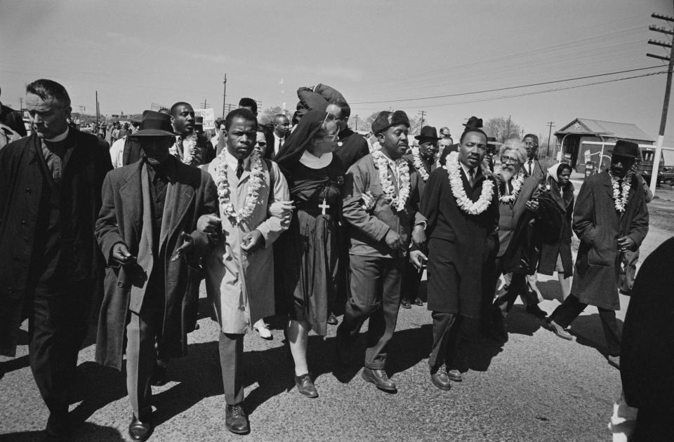 The Rev. Martin Luther King Jr., arm in arm with the Rev. Ralph Abernathy, leads marchers as they begin the march from Brown's Chapel Church in Selma, Alabama, on March 21, 1965. John Lewis, in a light-colored coat, joins the front line. (Photo: William Lovelace via Getty Images)