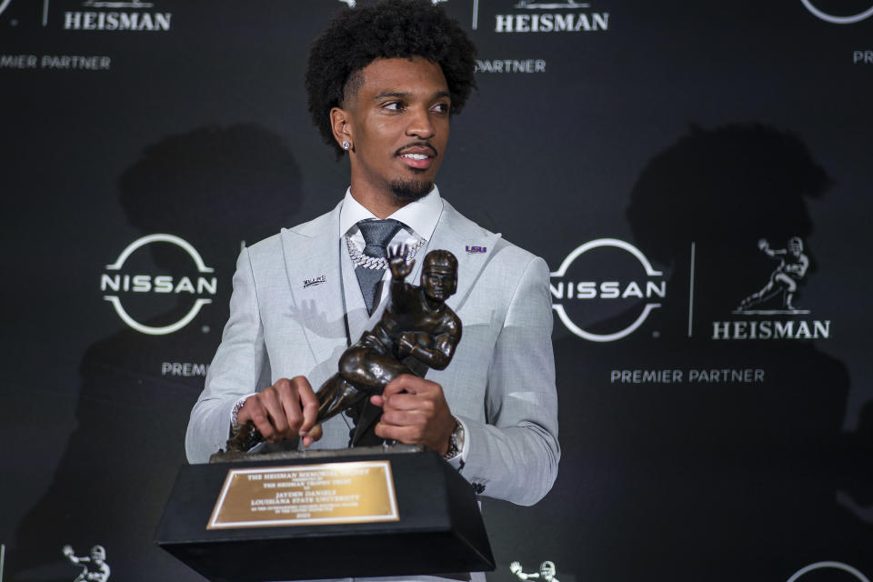 LSU quarterback Jayden Daniels, holds the Heisman Trophy during a news conference after winning the award, Saturday, Dec. 9, 2023, in New York. (AP Photo/Eduardo Munoz Alvarez)