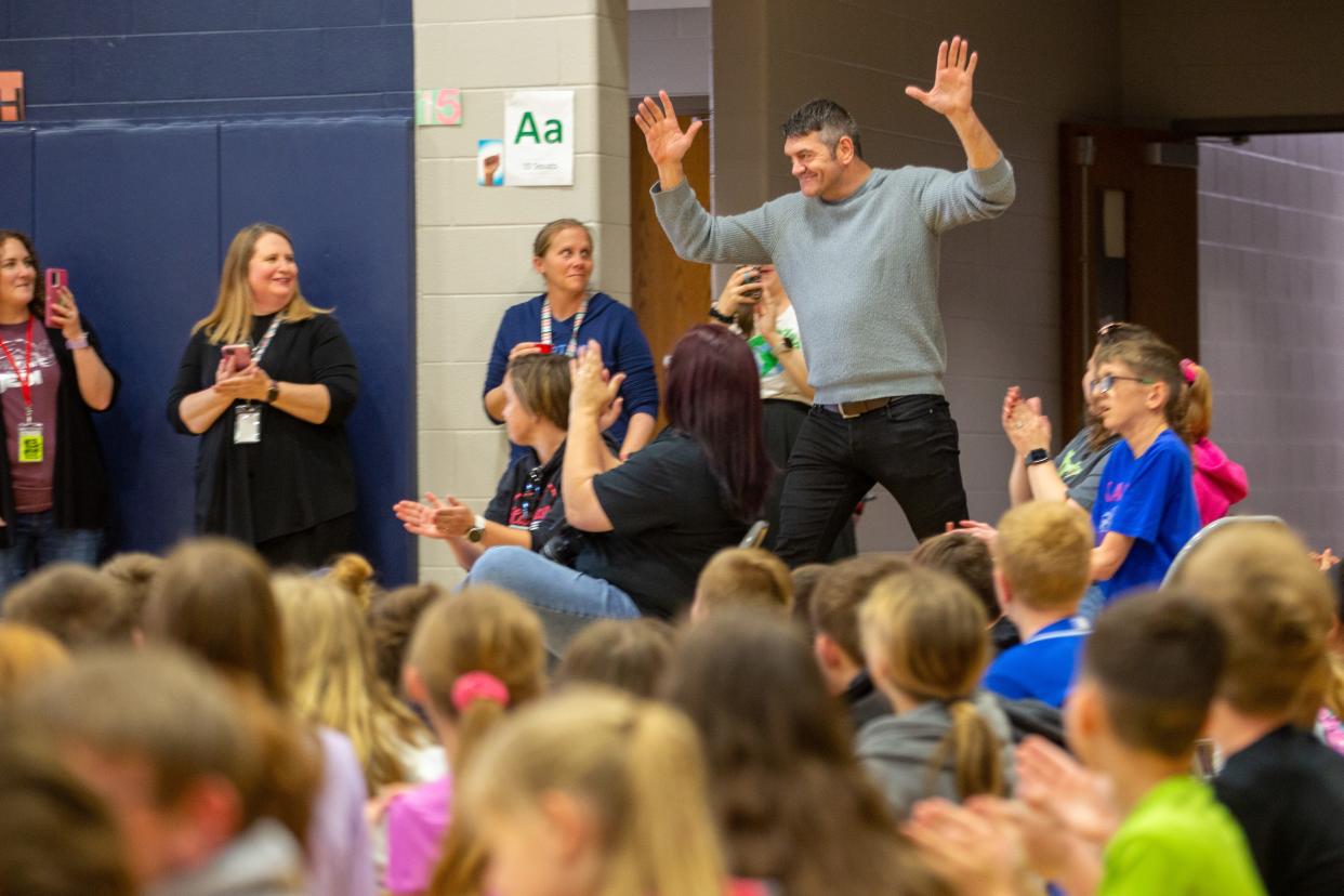 Spencer Wilding enters the West Indianola Elementary School gym on Monday to cheers and applause from hundreds of students and teachers.