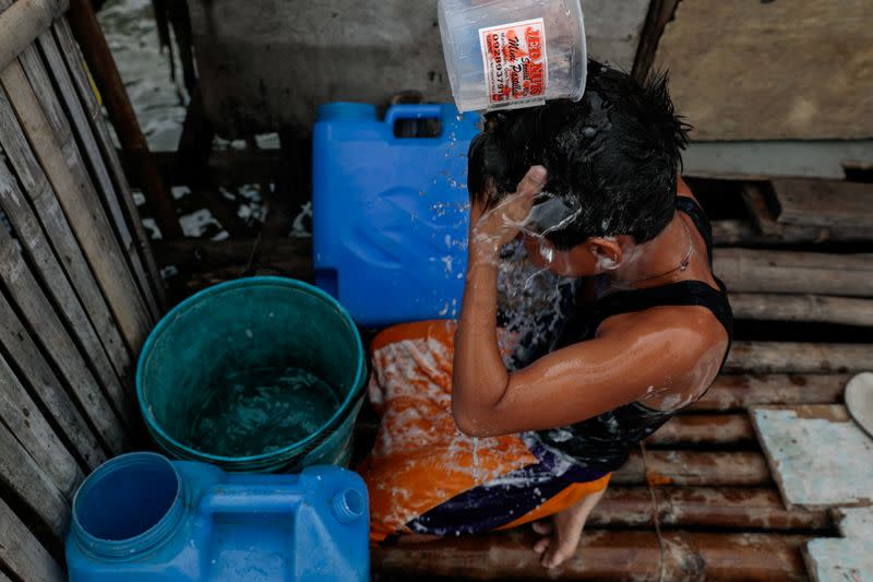 The Wider Image: Rising seas threaten early end for sinking village in Philippines