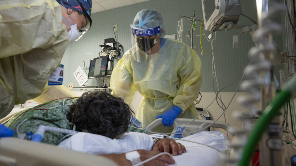 Nurses Assistant Vanessa Gutierrez, left, and Jamie McDonough, RN, talk to a COVID-19 patient in the COVID ICU at St. Joseph Hospital in Orange, CA on Wednesday, July 21, 2021. (Paul Bersebach/MediaNews Group/Orange County Register via Getty Images)