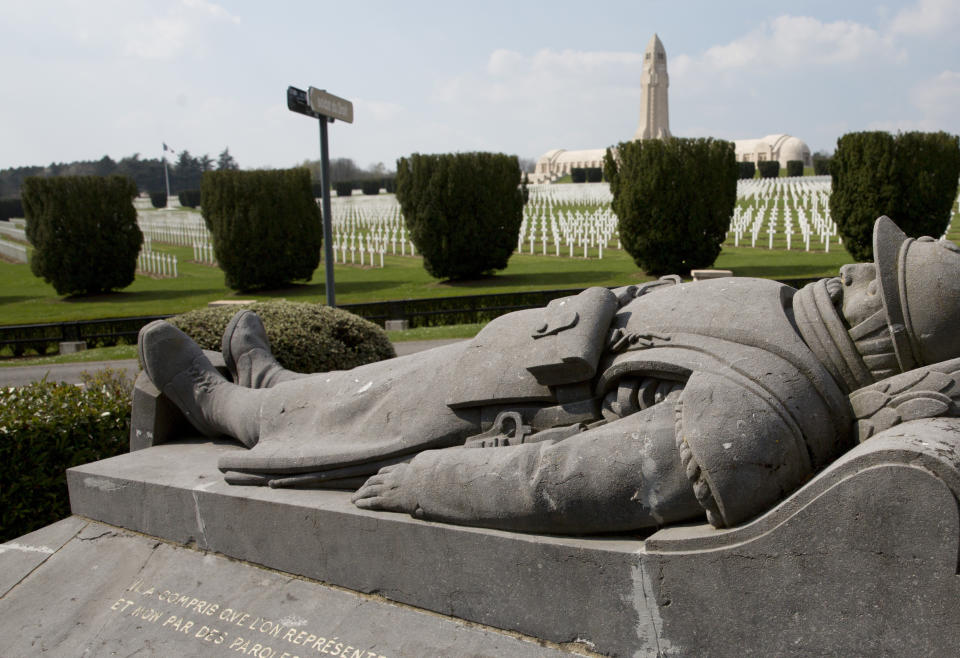 FILE- The statue of a French soldier in front of the Douaumont Ossuary in Verdun, France, April 3, 2017. With war ravaging Europe's heartland again, the countless headstones, cemeteries and memorials from World War I are a timeless testimony to its cruelty. Belgium and France want them recognized as UNESCO World Heritage sites to make sure people stop and think. (AP Photo/Virginia Mayo, File)