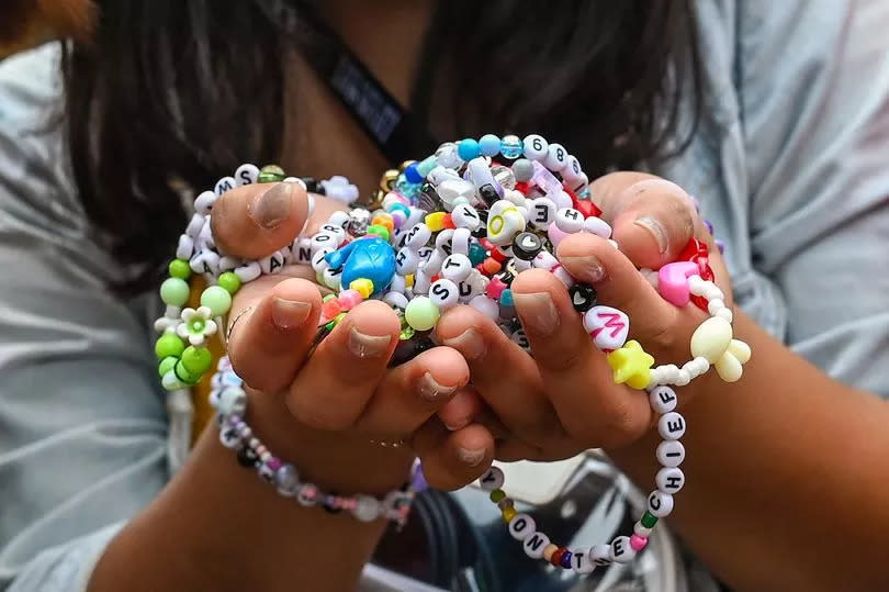 A fan of US singer Taylor Swift, also known as a Swiftie, holds friendship bracelets as she arrives for the first of the pop star's six sold-out Eras Tour concerts at the National Stadium in Singapore on March 2, 2024.