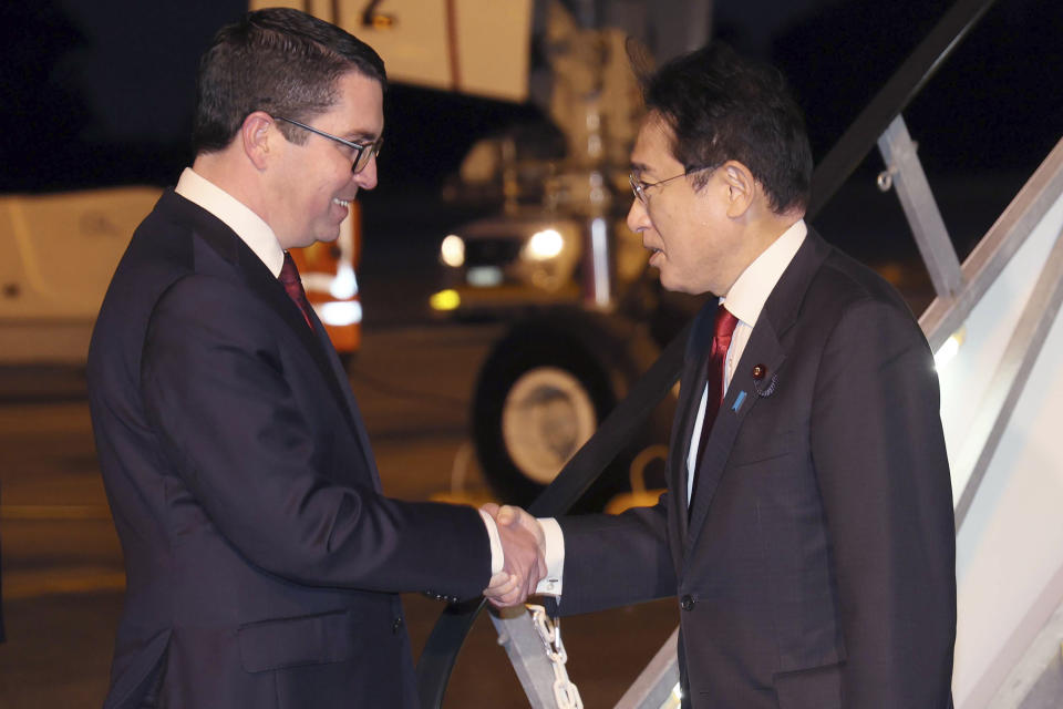 Japan's Prime Minister Fumio Kishida, right, is met by member of federal parliament Patrick Gorman as he arrives in Perth to begin a 3-day-visit to Australia on Friday, Oct. 21, 2022. (Trevor Collens/Pool Photo via AP)