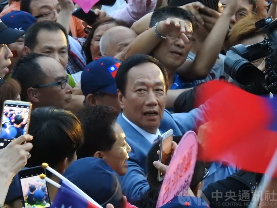 國民黨總統初選參選人郭台銘（穿西裝者）30日展開初選前唯一一場萬人造勢晚會，花了近半小時進場。（中央社）