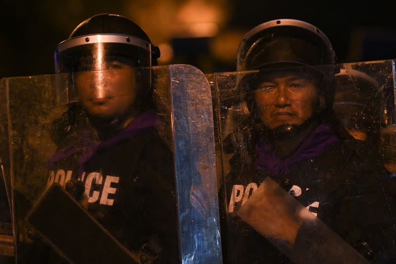 Police officers with riot shields take position during a gathering of pro-democracy protesters who demand the government to resign and to release detained leaders in Bangkok