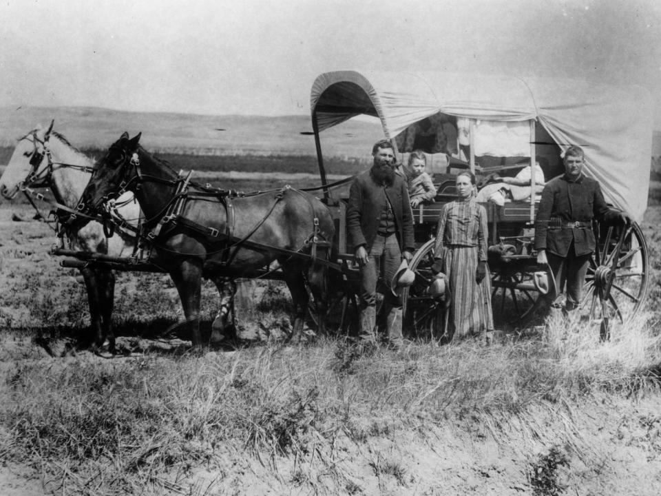 A family pose with their wagon in Loup Valley, Nebraska, on their way to their new homestead.