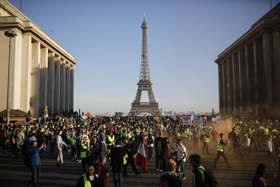 Yellow vest protesters walk past the Trocadero plaza as they demonstrate in the streets of Paris, France, Saturday, Feb. 23, 2019. French yellow vest protest organizers are trying to tamp down violence and anti-Semitism in the movement's ranks as they launch a 15th straight weekend of demonstrations. (AP Photo/Kamil Zihnioglu)