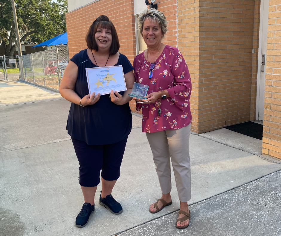 Cindi Parker-Pearson, principal of Achievement Academy, presented the Teacher of the Year award to Gina Mills, left.