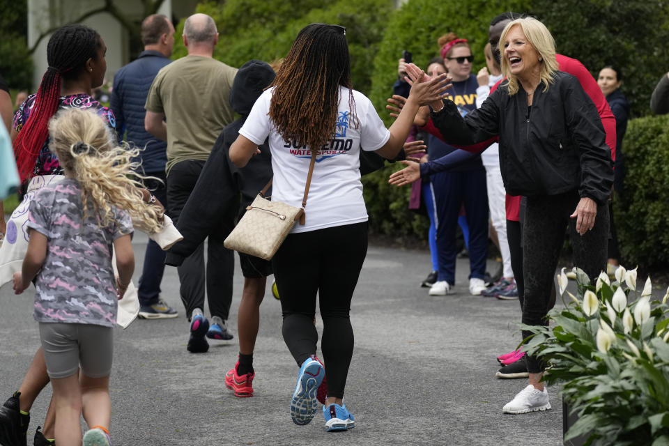 First lady Jill Biden high fives runners during the Joining Forces Military Kids Workout on the South Lawn of the White House in Washington, Saturday, April 29, 2023. The event is in honor of the Month of the Military Child. (AP Photo/Carolyn Kaster)