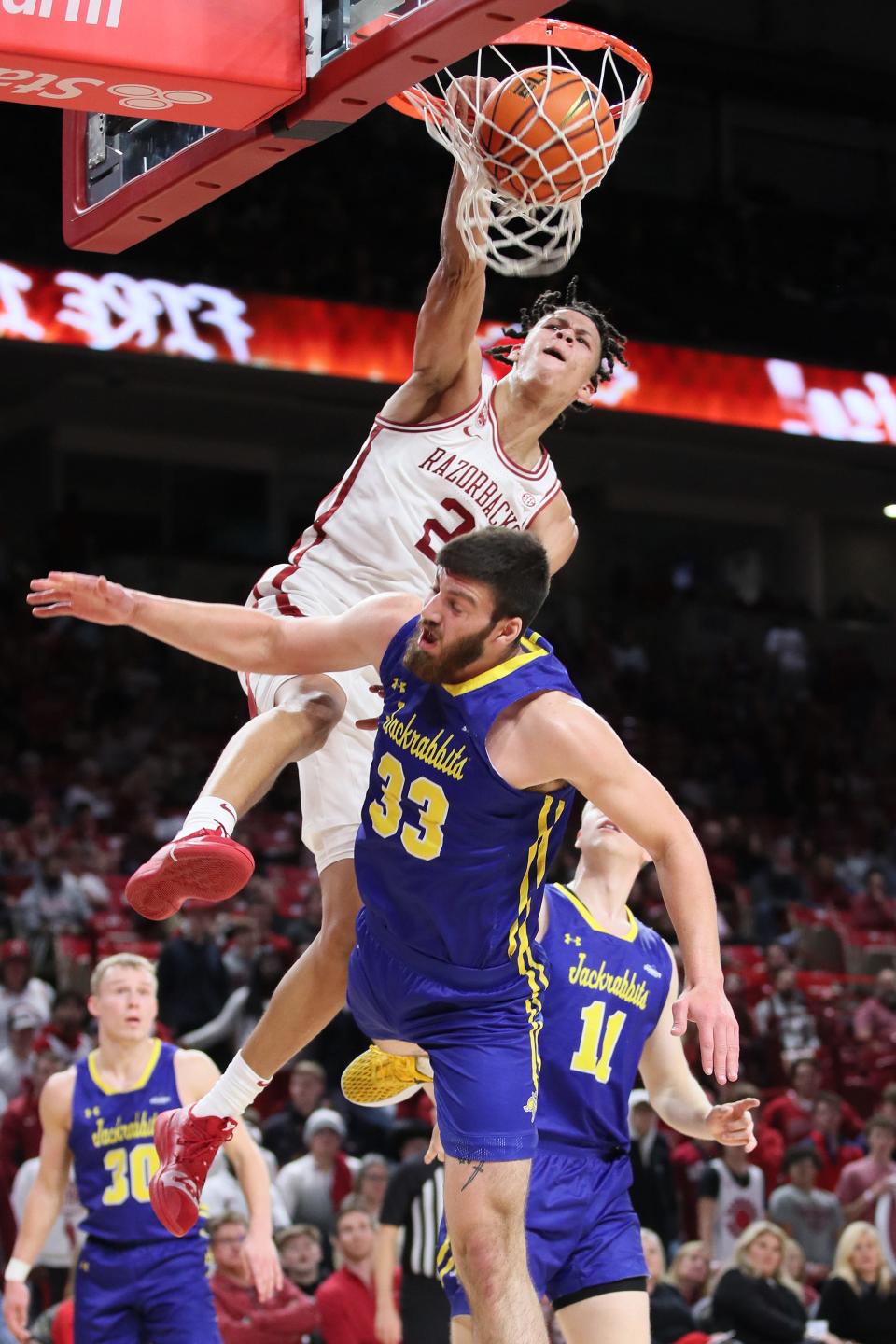 Nov 16, 2022; Fayetteville, Arkansas, USA; Arkansas Razorbacks forward Trevon Brazile (2) dunks the ball in the second half over South Dakota State Jackrabbits forward Broden Lien (33) at Bud Walton Arena. Mandatory Credit: Nelson Chenault-USA TODAY Sports