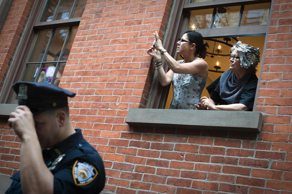 Unos vecinos graban un video con su móvil cerca de un policía en la ciudad de Nueva York. REUTERS/Keith Bedford (UNITED STATES - Tags: POLITICS SOCIETY)