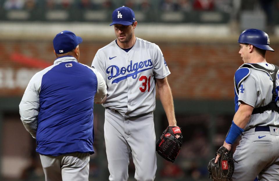 Los Angeles Dodgers manager Dave Roberts (30) pulls starting pitcher Max Scherzer (31) during the fifth inning against the Atlanta Braves in Game 2 of the 2021 NLCS at Truist Park.