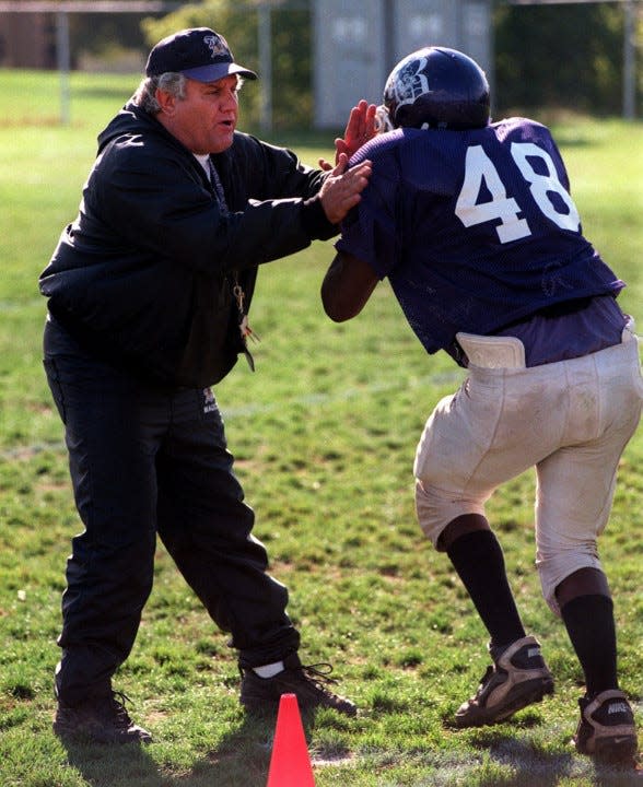 Tim Flossie works with a Barberton High School football player in an undated photo.