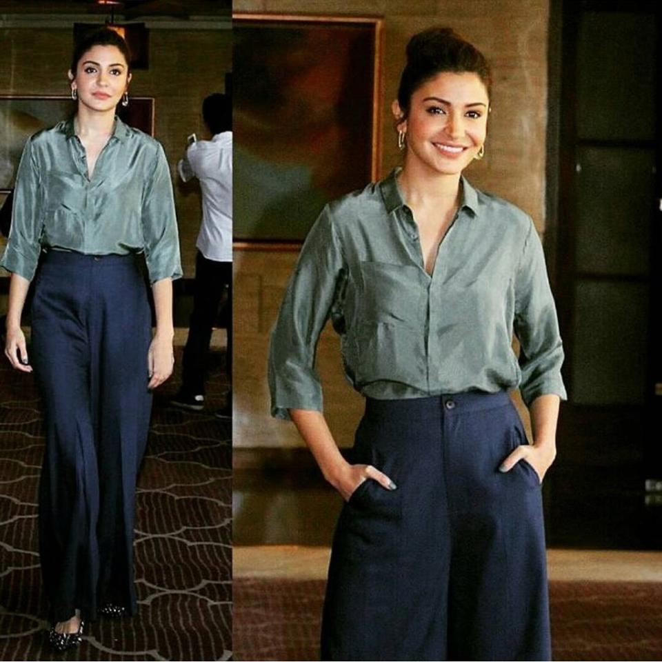Anushka Sharma paired a military green silk shirt with black wide legged trousers. 