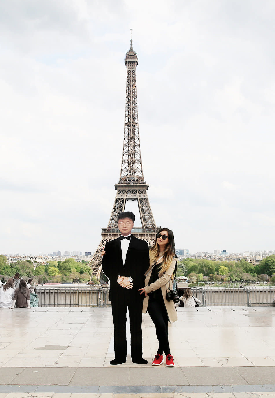 Jinna Yang and a cutout of her father in front of Paris's Eiffel Tower.