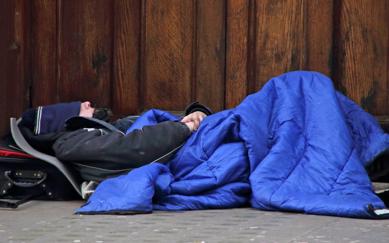 A homeless man sleeps at a doorway in central London - LightRocket 