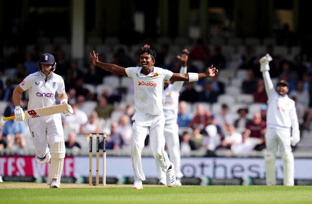 Vishwa Fernando, centre, successfully appeals for the wicket of Joe Root, left