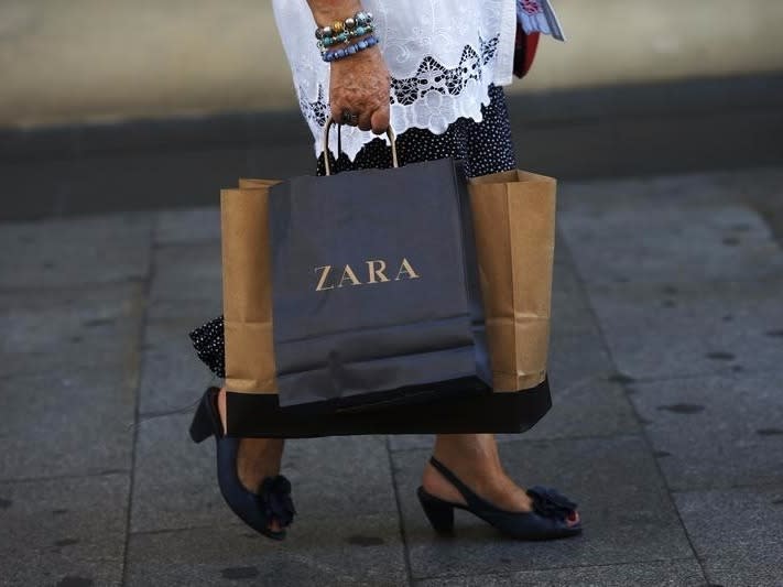 A woman walks with a Zara bag in hand in Madrid September 19, 2012. REUTERS/Susana Vera 