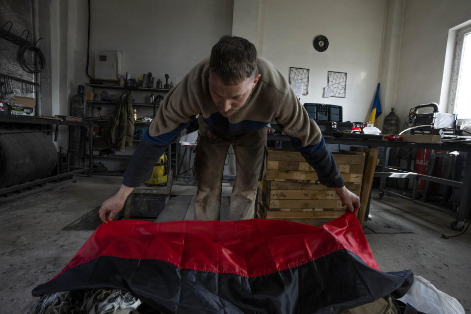 Car welder Ostap Datsenko, 31, places the Ukrainian Insurgent Army flag on items that will be sent to soldiers on the frontlines, at a welding workshop in Lviv, western Ukraine, Sunday, March 27, 2022. Ukraine’s military has put up a resistance to Russia’s invasion that has surprised some observers. One of its weapons is a parallel army of volunteers who are busy mobilizing funding and supplies ranging from body armor to cigarettes. (AP Photo/Nariman El-Mofty)