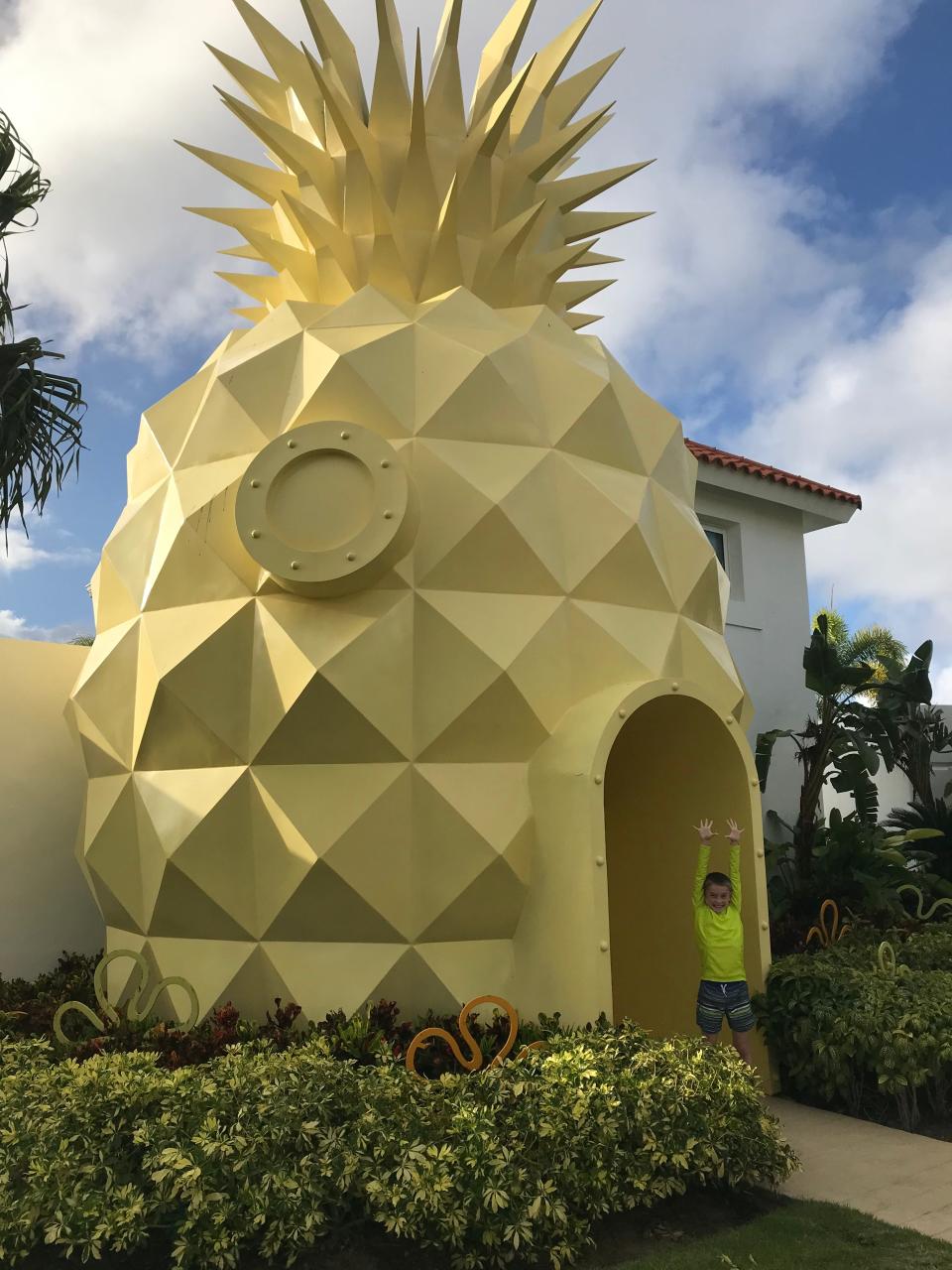 A boy stands outside the Pineapple Villa at The Nickelodeon Hotel