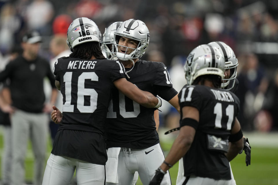 Las Vegas Raiders quarterback Jimmy Garoppolo, center, greets teammate wide receiver Jakobi Meyers (16) before an NFL football game against the New England Patriots, Sunday, Oct. 15, 2023, in Las Vegas. (AP Photo/John Locher)