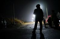 Security members keep watch at an entrance to the Hushan gold mine, where workers are trapped underground after the January 10 explosion, in Qixia