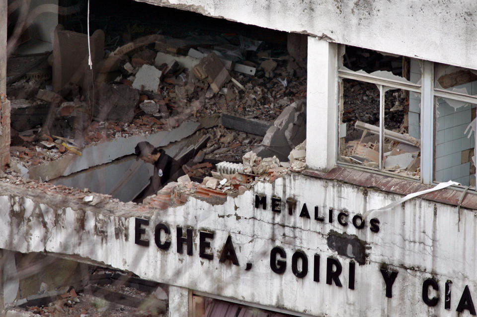 FILE - In this Feb. 22, 2006 file photo, a Basque policeman looks over the damage after a bomb exploded outside a cannery in an industrial area of Bilbao, northern Spain. Josu Urrutikoetxea, the last known chief of ETA, the now-extinct Basque separatist militant group, goes on trial Monday Oct. 19, 2020 in Paris for terrorism charges that he deems “absurd” because of his role in ending a conflict that claimed hundreds of lives and terrorized Spain for half a century. (AP Photo/Alvaro Barrientos, file)