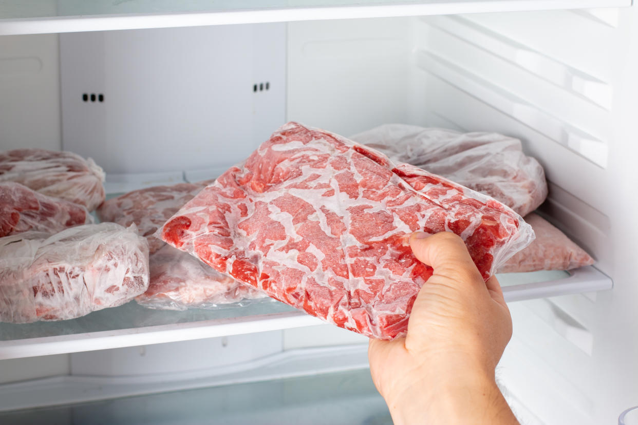 Man taking out frozen meat from freezer. Frozen food�