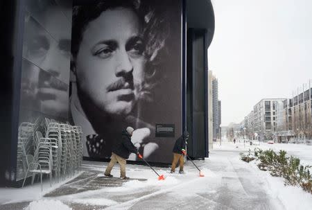 People shovel snow from the sidewalks outside the Guthrie Theater during the spring snowstorm in Minneapolis, Minnosta, U.S., April 11, 2019. REUTERS/Annabelle Marcovici